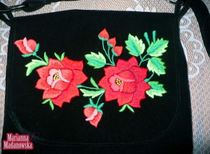 Motyw z czerwonymi haftowanymi ręcznie łowickimi różami na torebce damskiej